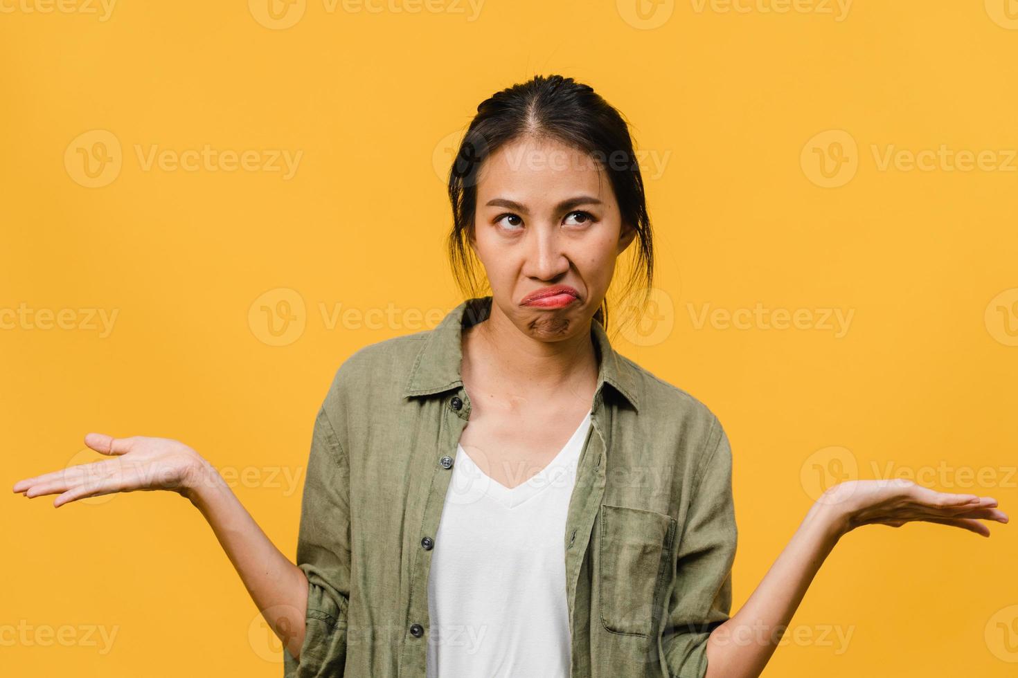 portret van jonge Aziatische dame met negatieve uitdrukking, opgewonden schreeuwen, huilen emotioneel boos in casual kleding geïsoleerd op gele achtergrond met lege kopie ruimte. gezichtsuitdrukking concept. foto