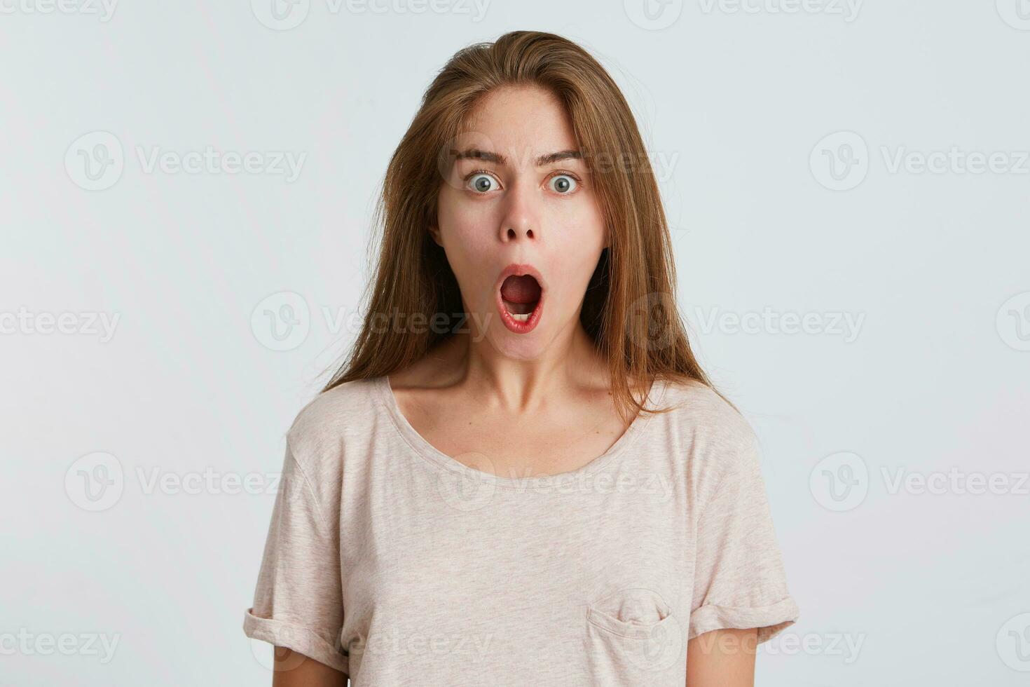 portret van verrast verbaasd jong vrouw met geopend mond draagt t overhemd looks versteld staan en geschreeuw geïsoleerd over- wit achtergrond foto