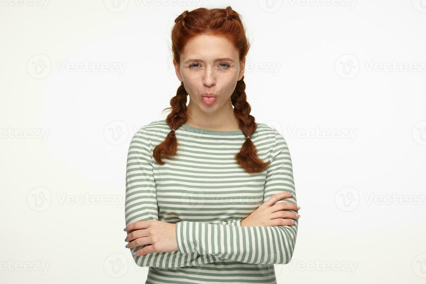 binnen- portret van jong gember vrouw staand over- wit achtergrond tonen haar tong met boos gelaats uitdrukking foto
