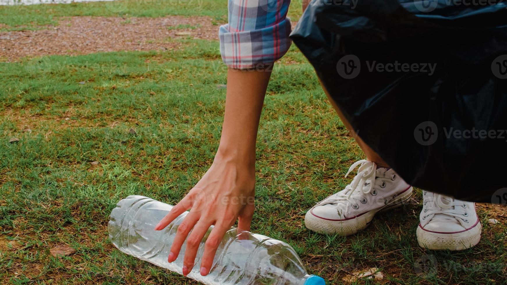 gelukkige jonge azië-activisten die plastic afval verzamelen op het strand. Koreaanse vrouwelijke vrijwilligers helpen de natuur schoon te houden en vuilnis op te halen. concept over milieubehoud vervuilingsproblemen. foto