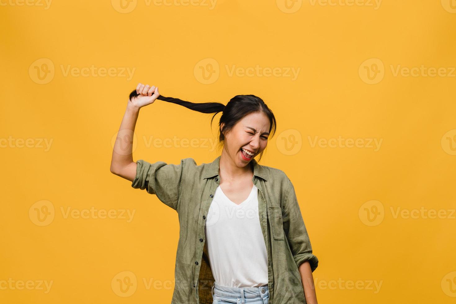 portret van jonge Aziatische dame met positieve uitdrukking, breed glimlachen, gekleed in casual kleding op gele achtergrond. gelukkige schattige blije vrouw verheugt zich over succes. gezichtsuitdrukking concept. foto