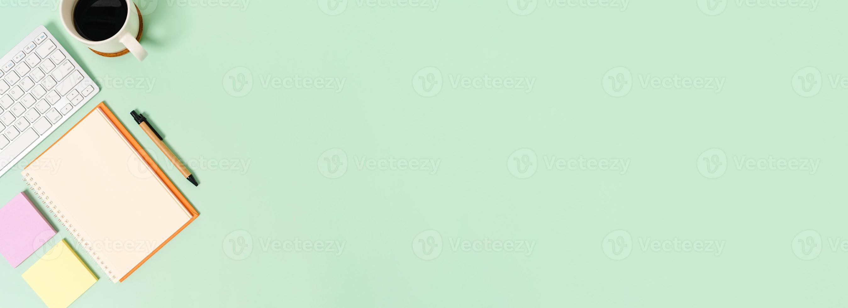 creatieve platliggende foto van een werkruimtebureau. bovenaanzicht bureau met toetsenbord en open mockup zwarte notebook op pastel groene kleur achtergrond. bovenaanzicht mock-up met kopieerruimtefotografie.