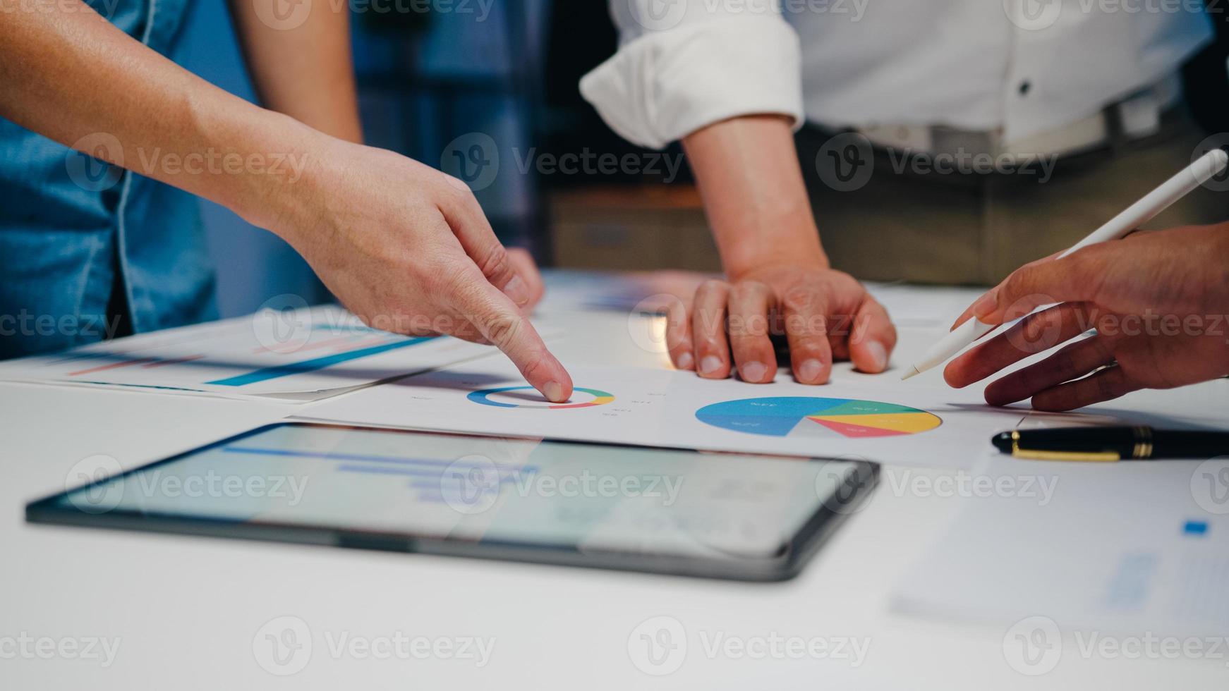 millennial azië zakenlieden en zakenvrouwen die brainstormen over ideeën over nieuwe papierwerkprojectcollega's die samenwerken bij het plannen van successtrategie genieten van teamwork in een klein modern nachtkantoor. foto