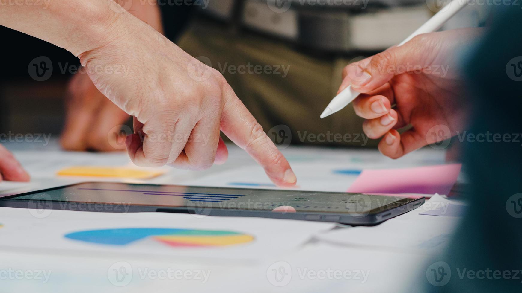 millennial azië zakenlieden en zakenvrouwen die brainstormen over ideeën over nieuwe papierwerkprojectcollega's die samenwerken bij het plannen van successtrategie genieten van teamwork in een klein modern nachtkantoor. foto