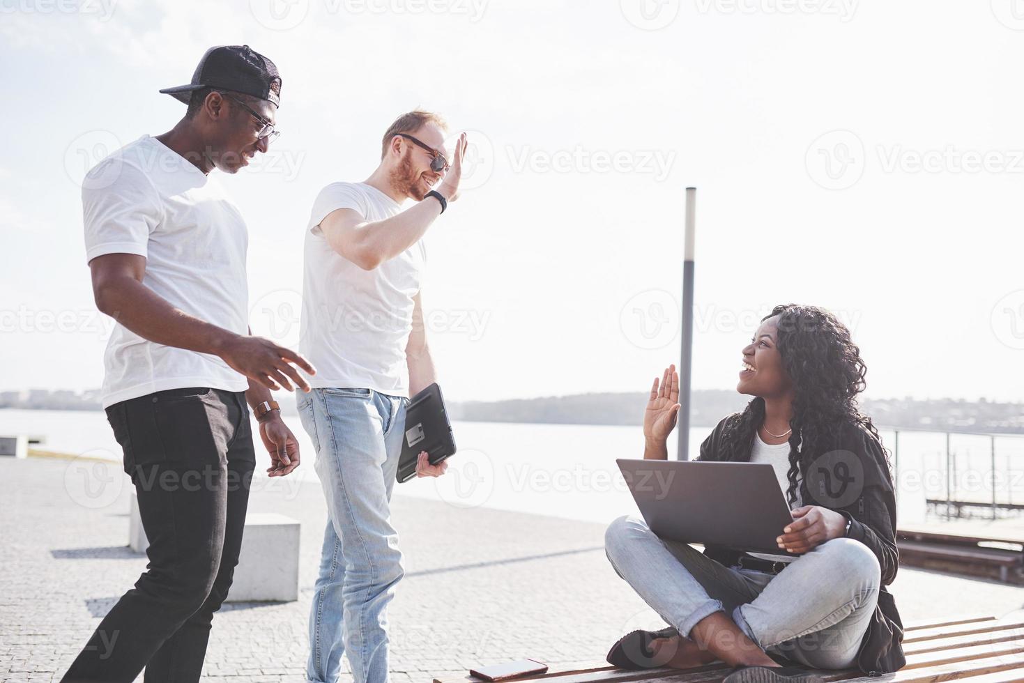 mooie multi-etnische vrienden die een laptop op straat gebruiken. jeugd levensstijl concept foto