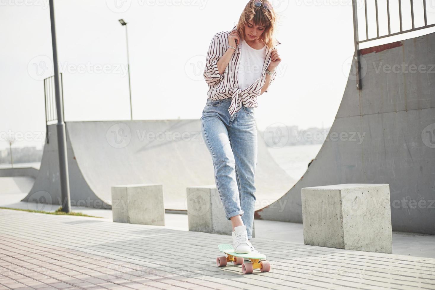 een jonge sportvrouw die op een skateboard in een park rijdt. foto