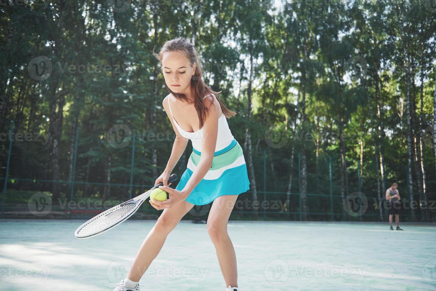 een mooie vrouw die een tennisbaan met sportkleding draagt op de baan foto