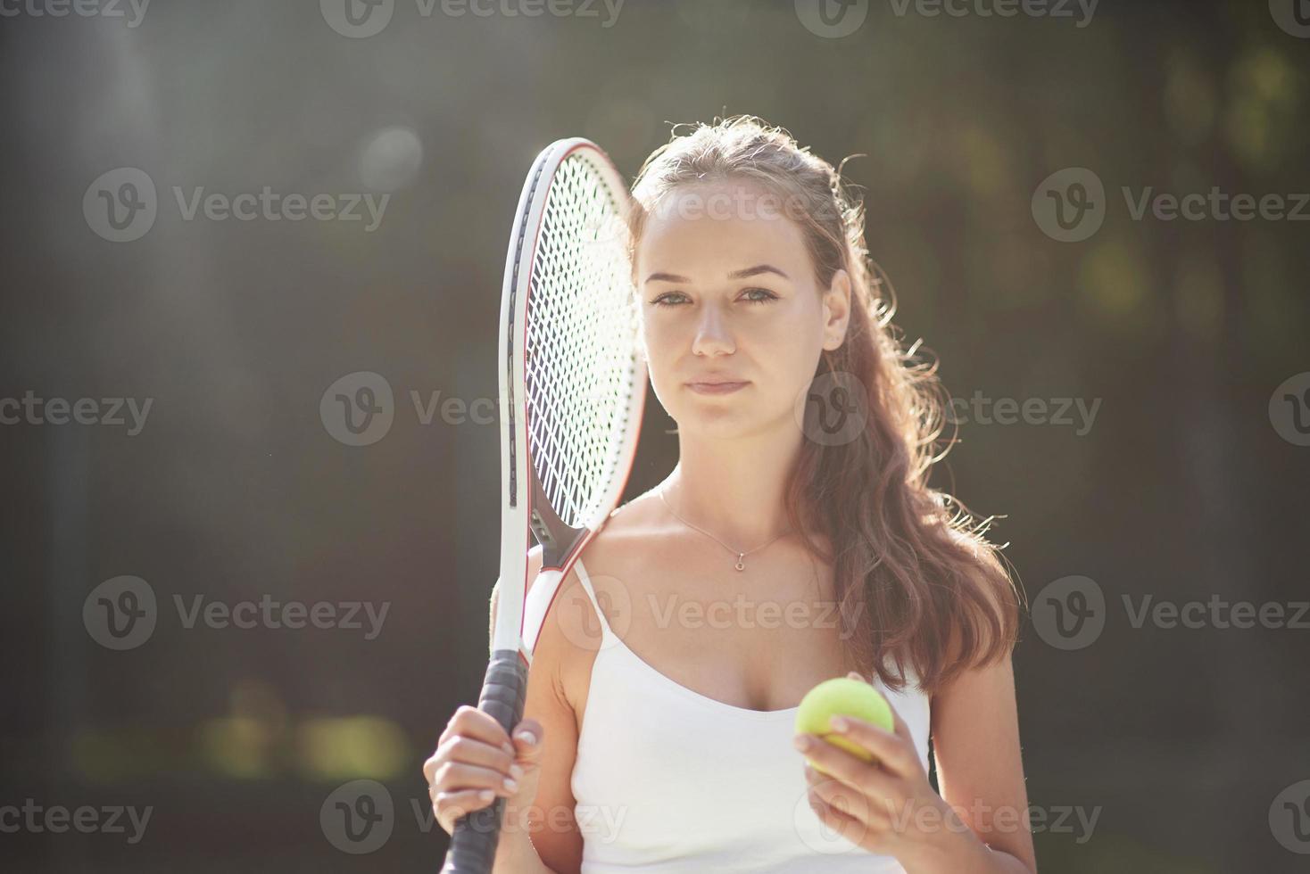 een mooie vrouw die een sportkleding tennisbal draagt. foto