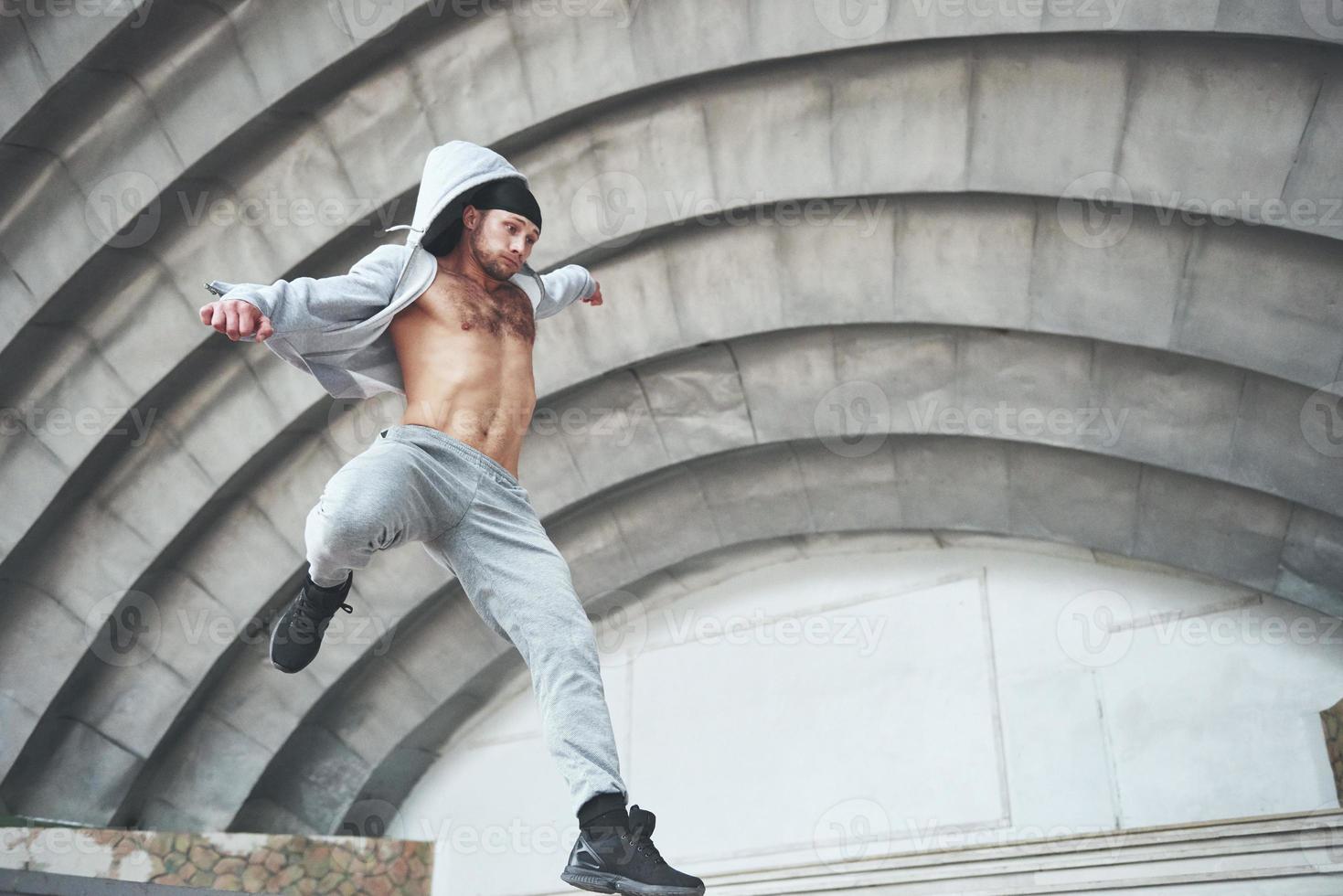 man die zich bezighoudt met parkour springen op straat training. foto