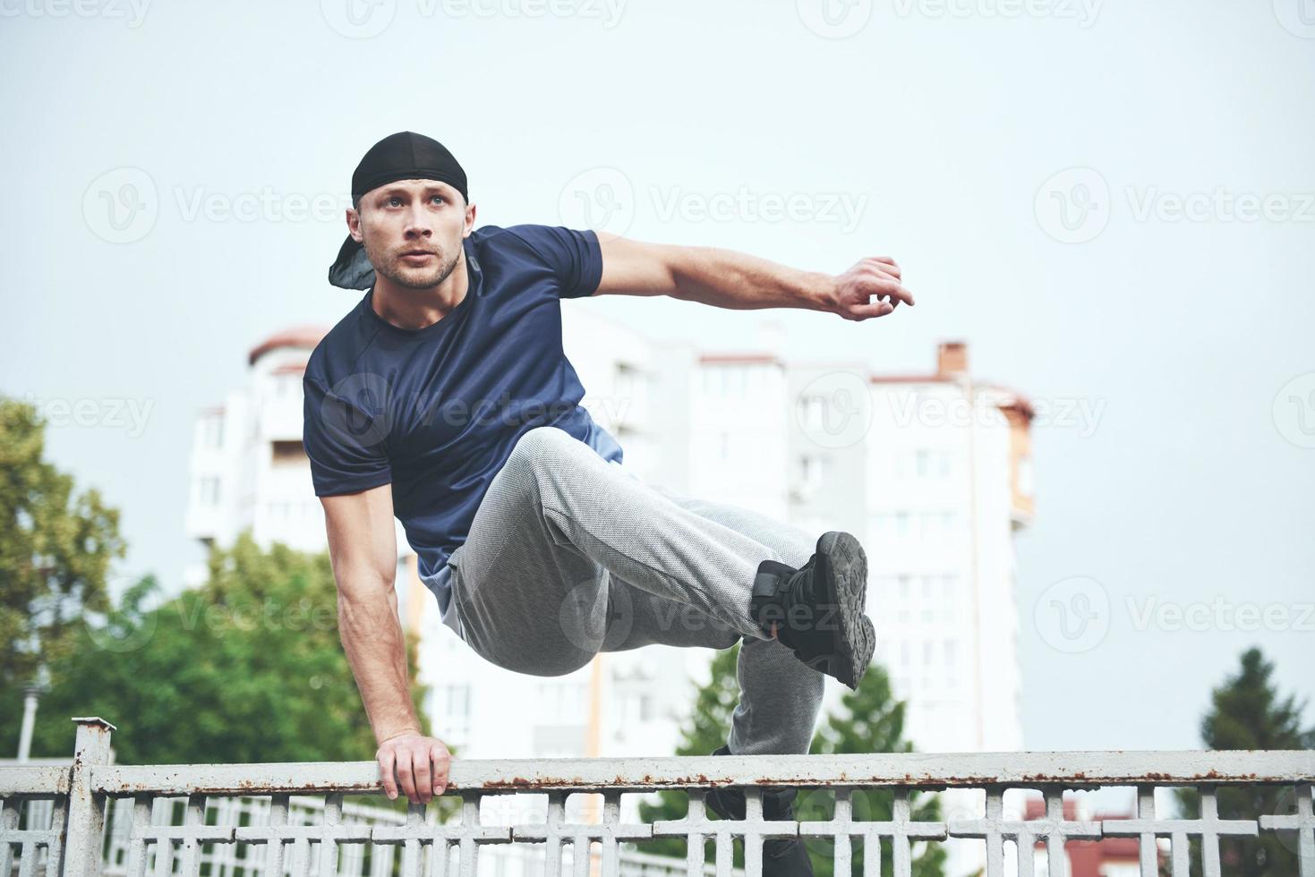 jonge sportman die parkour in de stad doet. foto