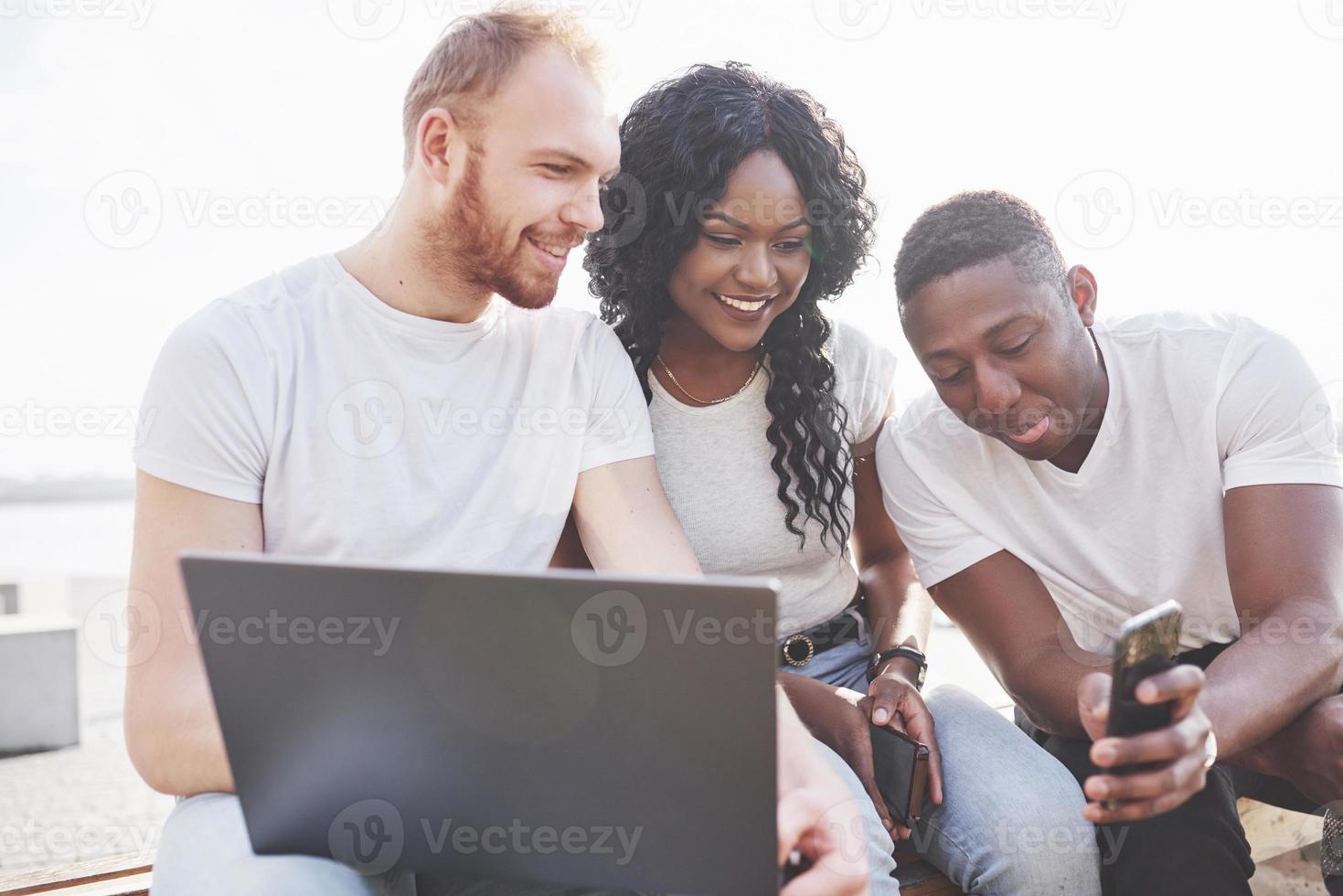 mooie multi-etnische vrienden die een laptop op straat gebruiken. jeugd levensstijl concept foto