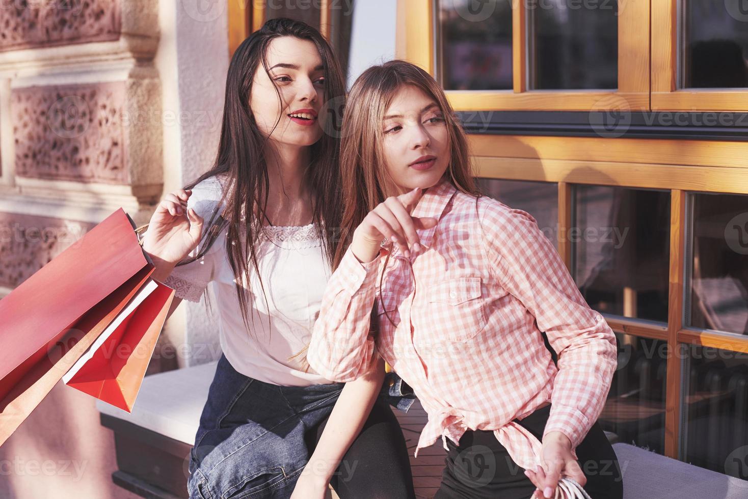 twee vrouwen praten na het winkelen op straat bij het raam foto