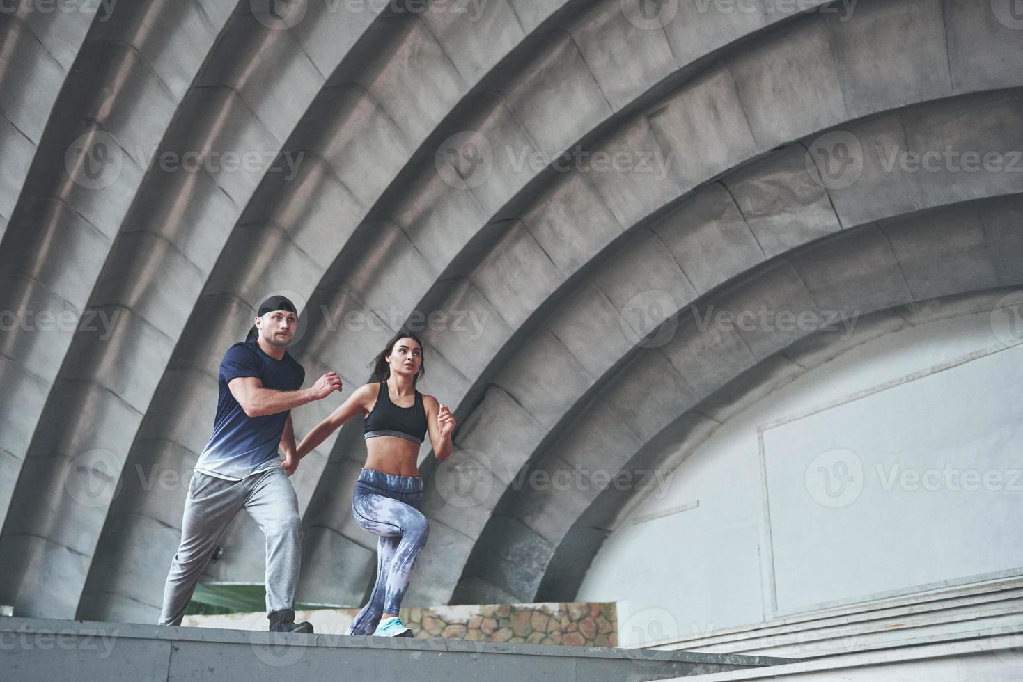 jong gelukkig sportpaar in de stadsstraat, die parkour uitvoert. foto