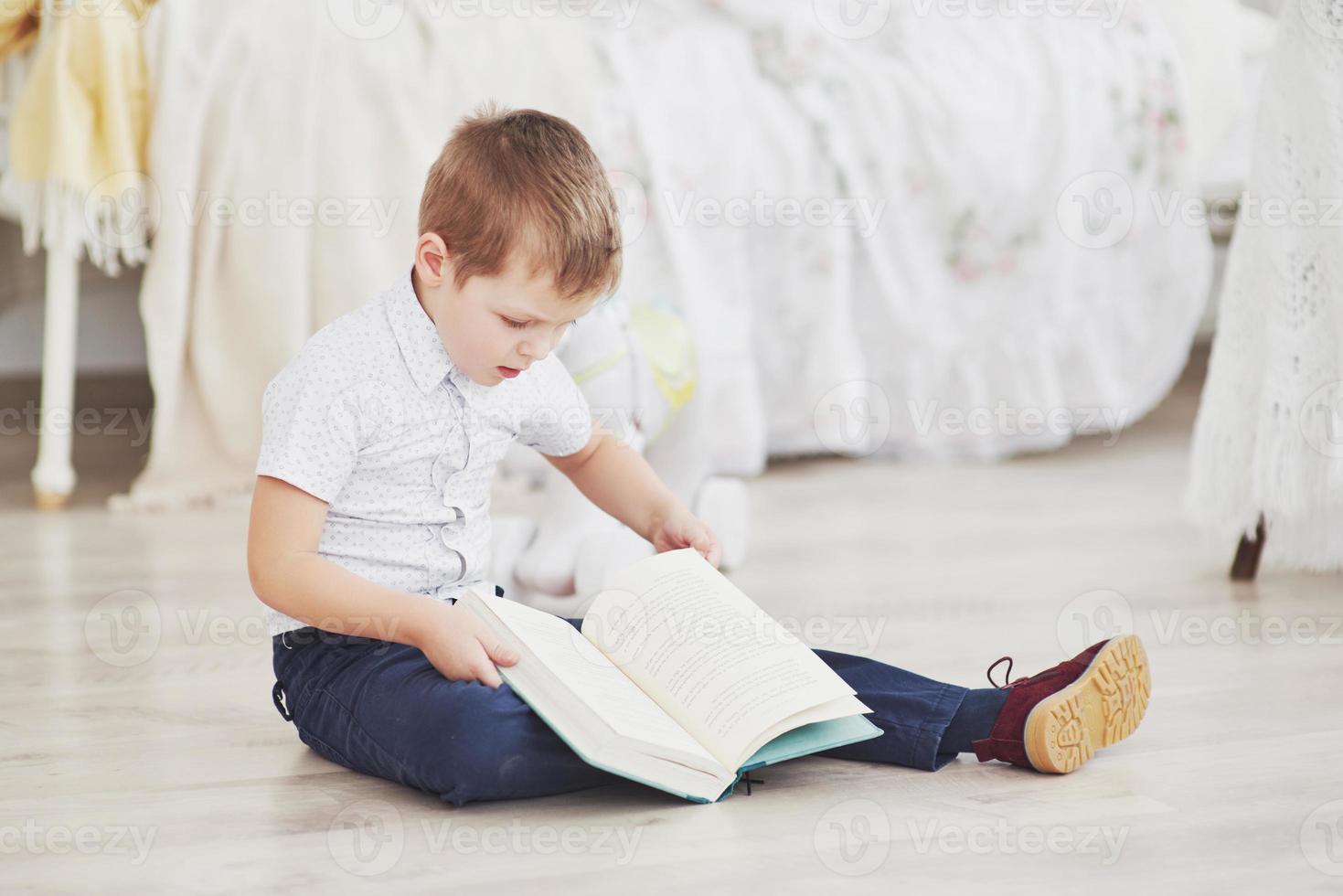 schattige kleine jongen gaat voor het eerst naar school. kind met schooltas en boek. Kid maakt een aktetas, kinderkamer op een achtergrond. terug naar school foto