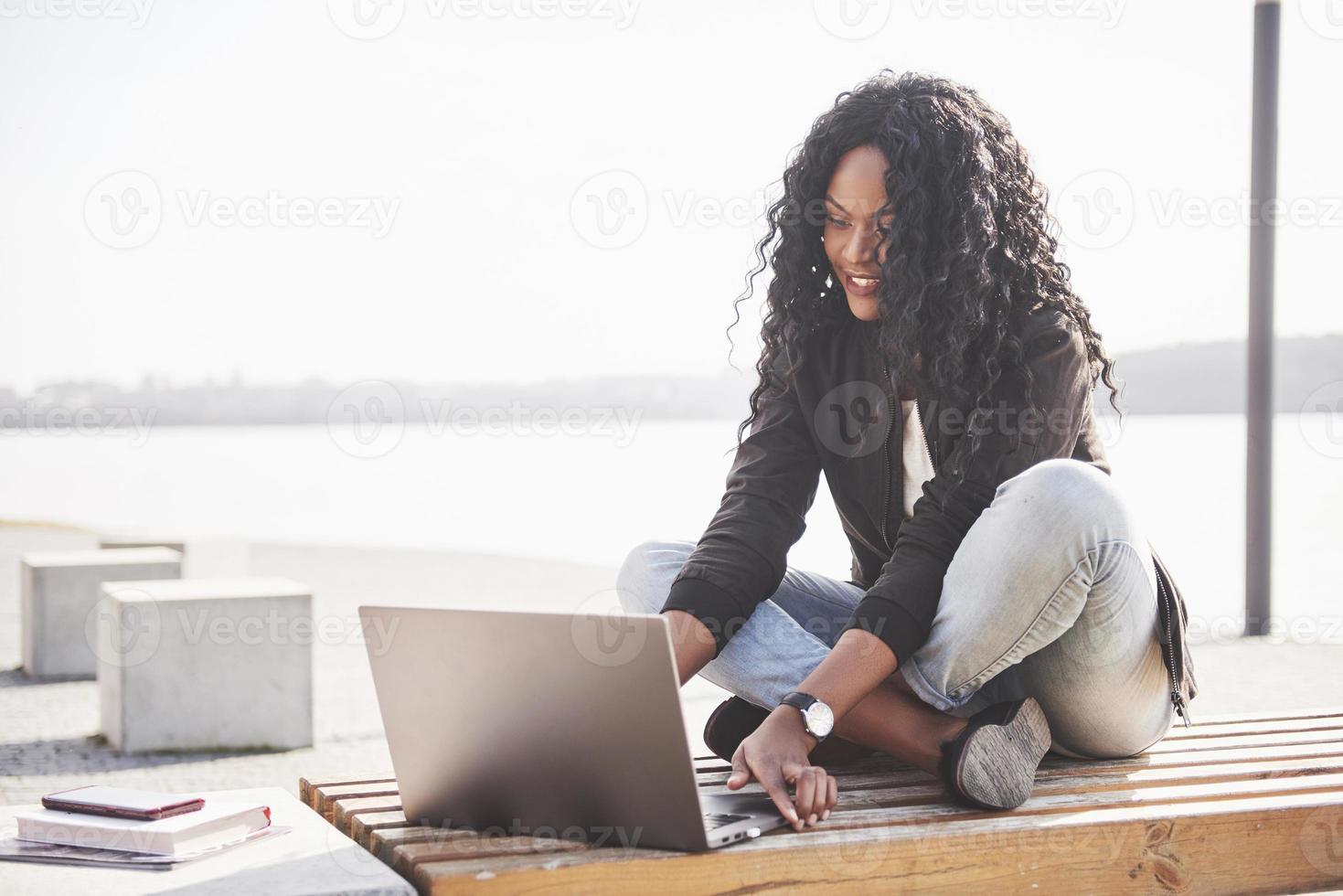 jonge vrouw op straat die aan laptop werkt foto