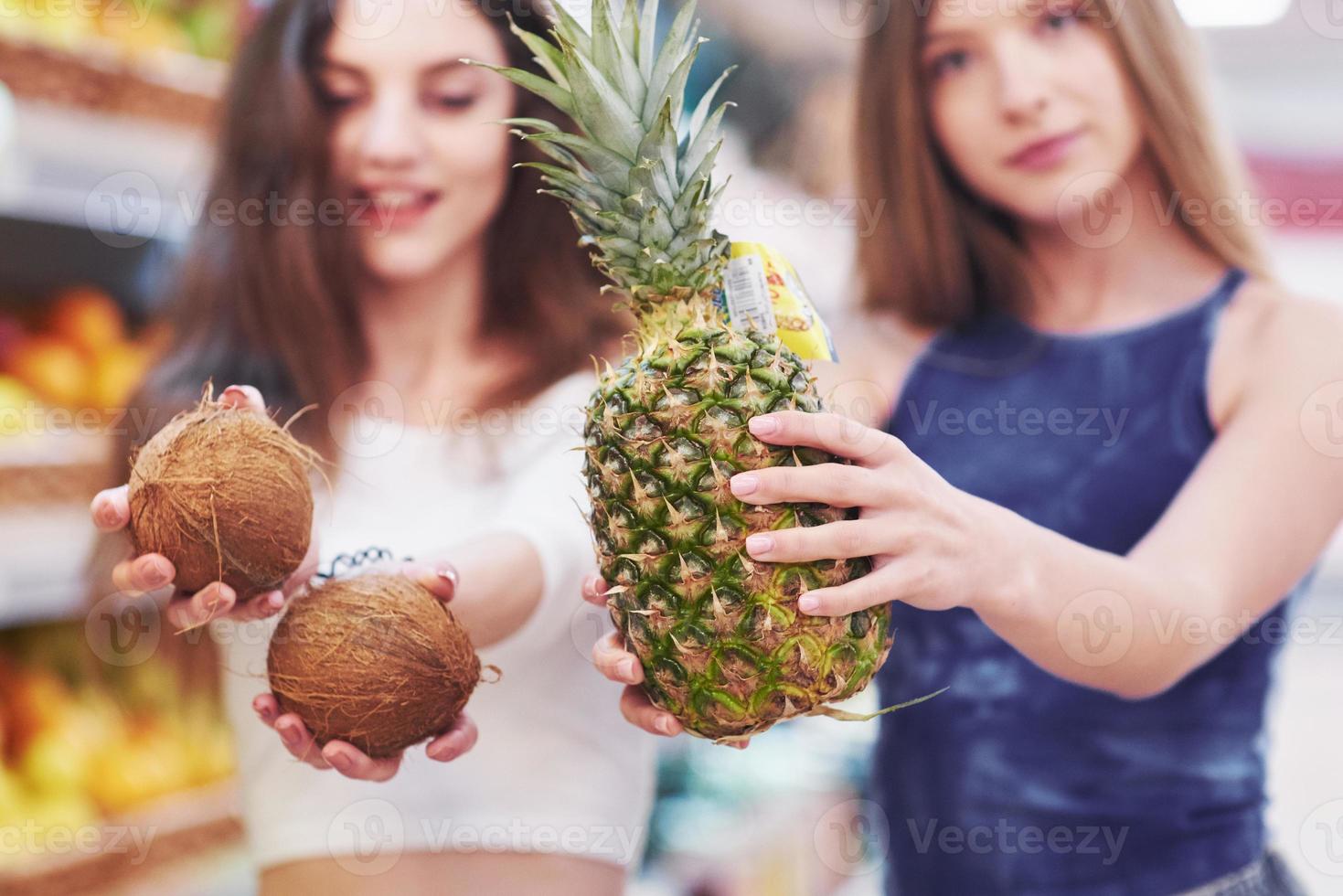 twee vrouwen kiezen het fruit in een supermarkt foto