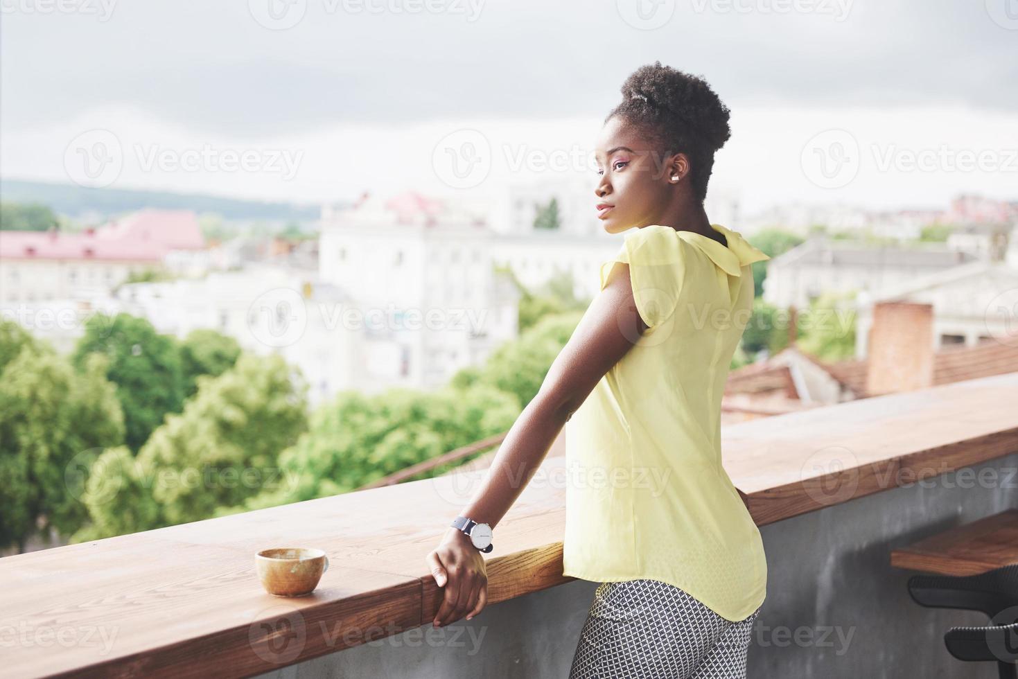 mooie jonge Afro-Amerikaanse zakenvrouw koffie drinken in een café. mooie gezellige plek foto