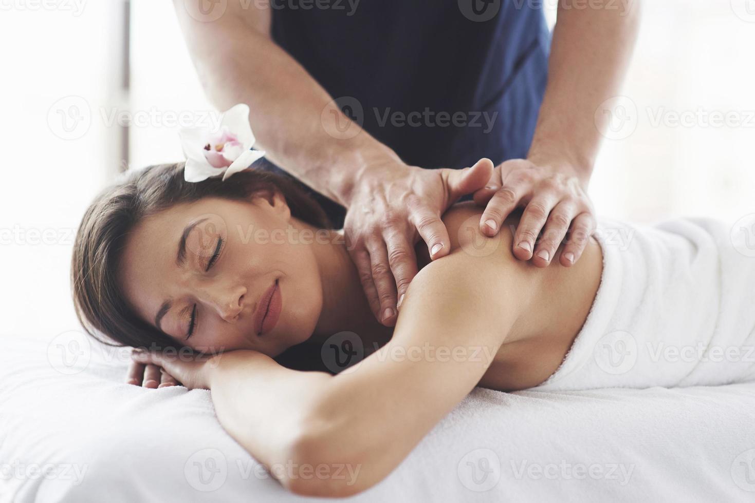mooie jonge vrouw ontspannen met handmassage in beauty spa. foto