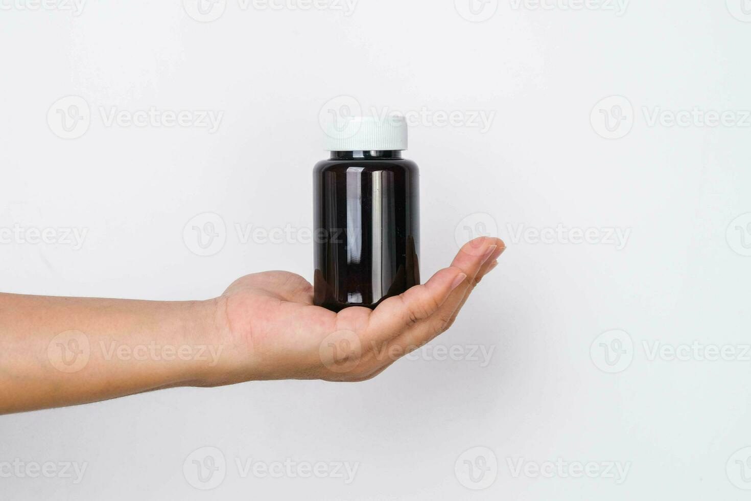 vrouw hand- Holding blanco pil fles geïsoleerd Aan wit achtergrond. verpakking voor pil, capsule of supplement met kopiëren ruimte voor tekst. foto