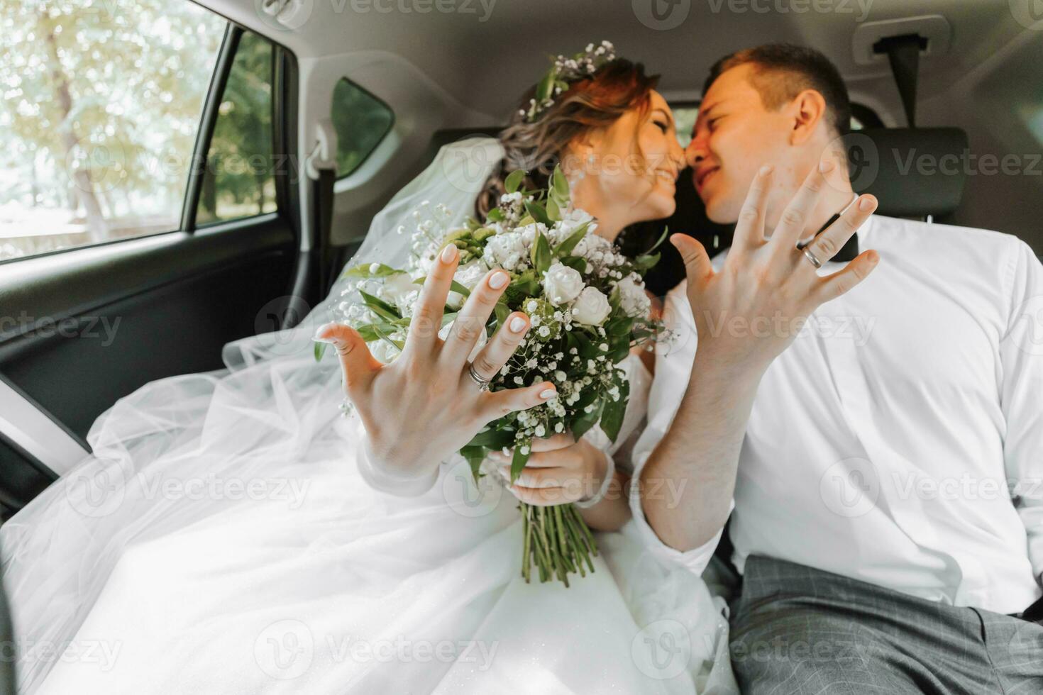 jong gelukkig bruid en bruidegom zijn verheugt na de bruiloft ceremonie in hun auto foto