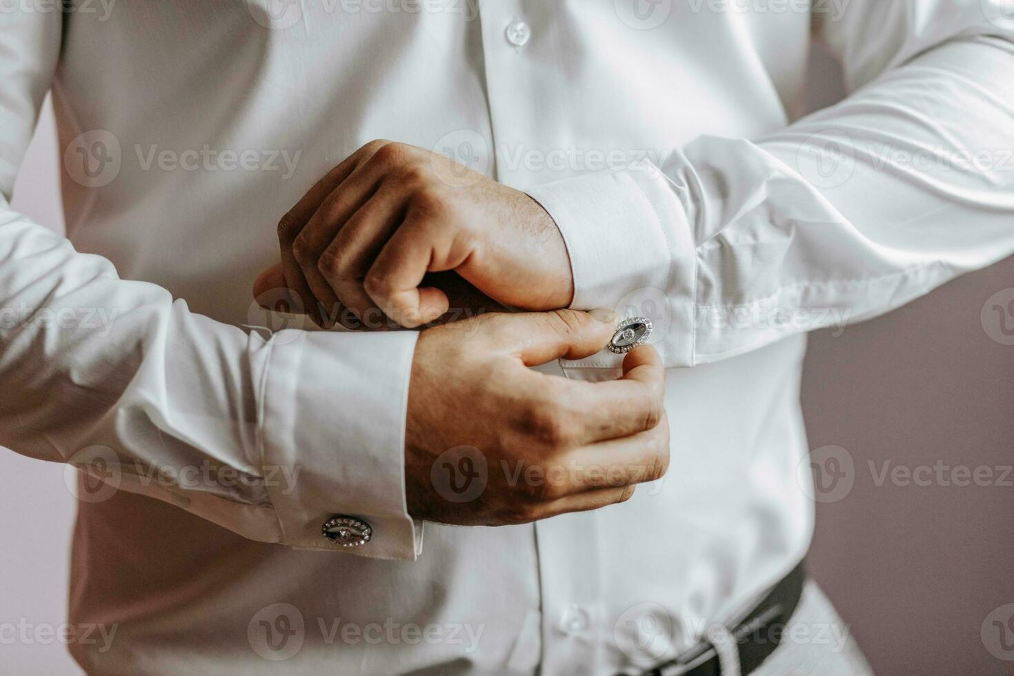 detailopname van een Mens knopen zijn shirt. de bruidegom is voorbereidingen treffen voor de bruiloft. de Mens draagt een wit shirt. elegant bruidegom foto