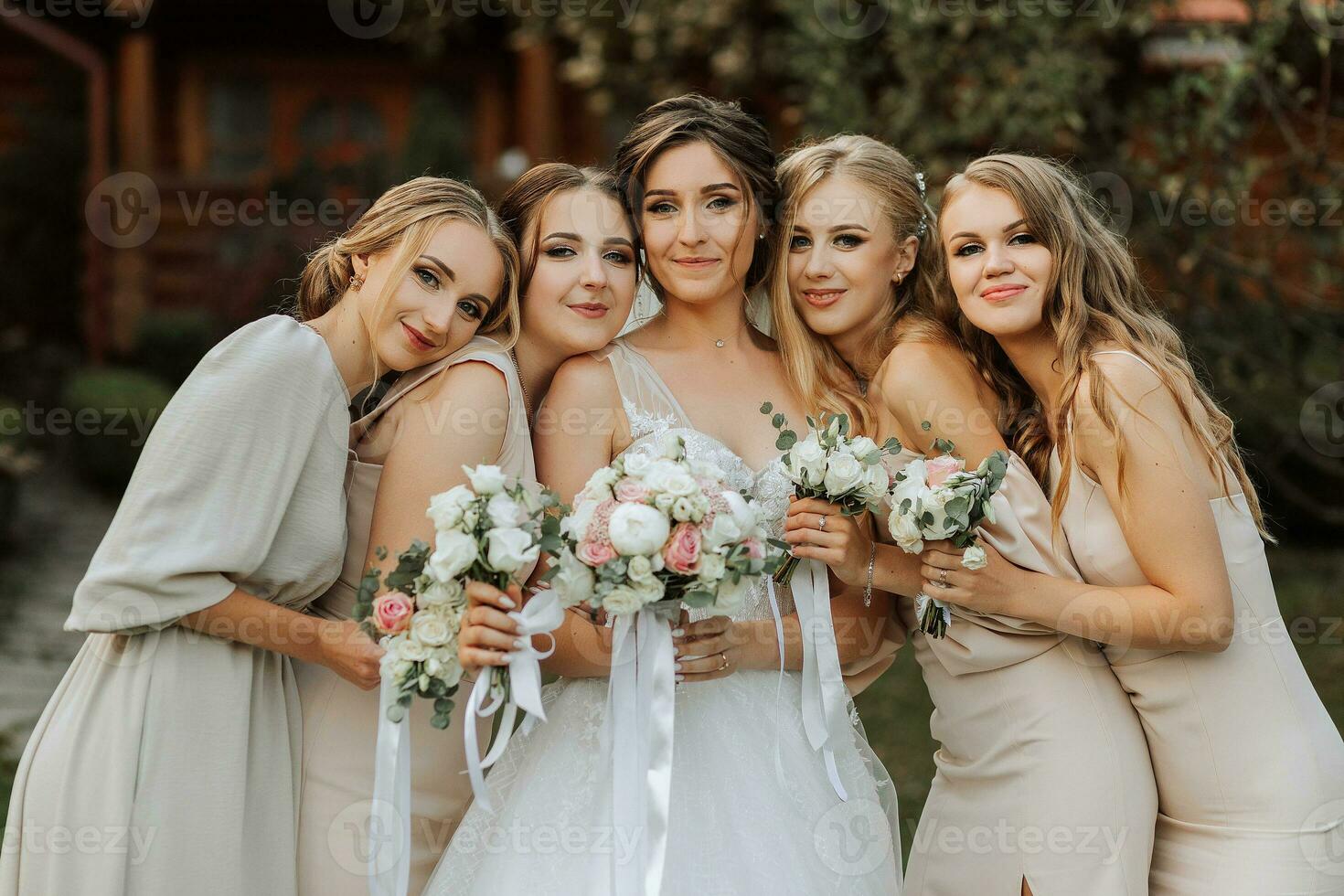 groep van mooi Dames in identiek jurken lachend, vieren en hebben pret samen. vrienden van de bruid vieren de bruiloft samen met de bruid in natuur foto