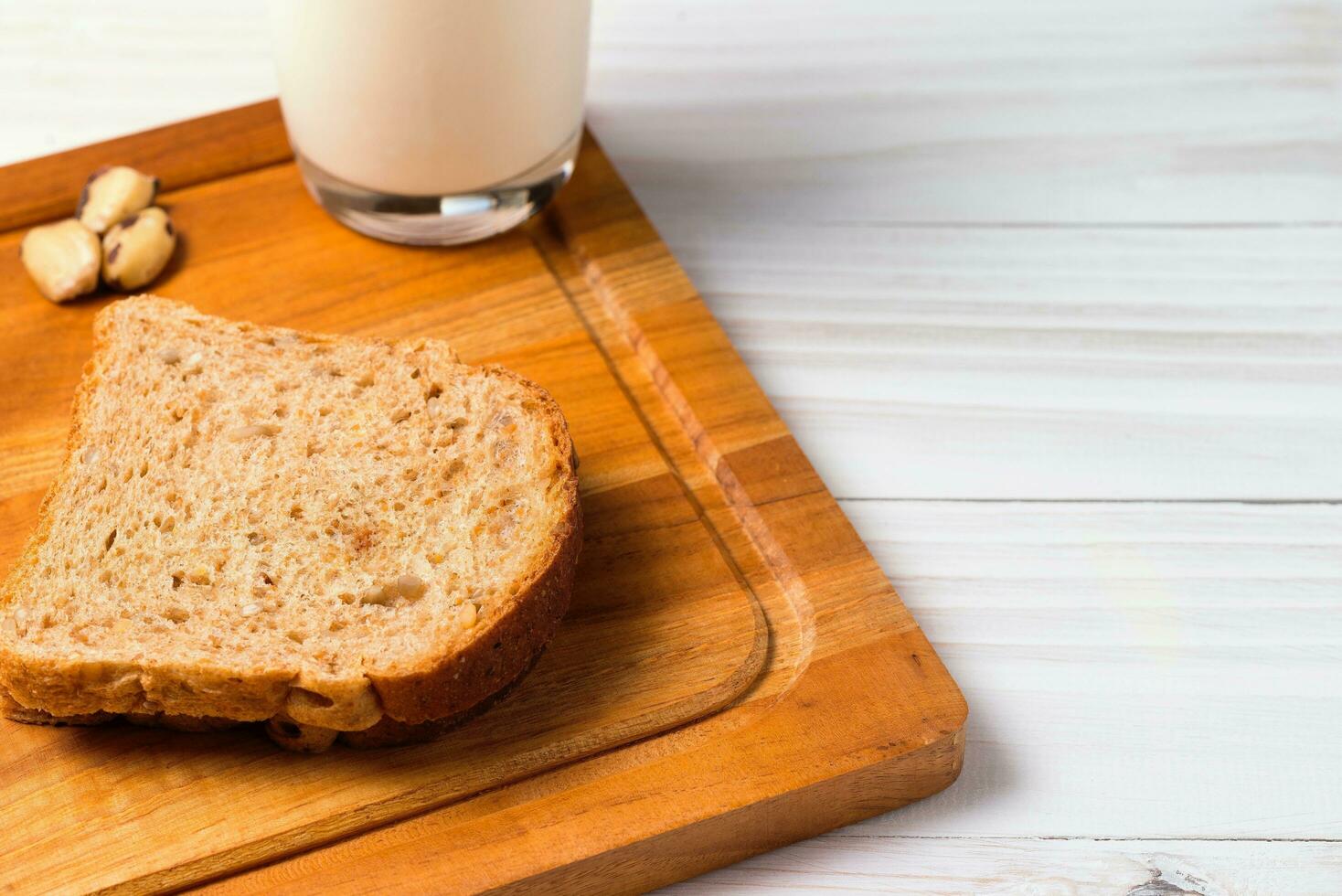 glas van melk en brood Aan houten tafel. gezond ontbijt concept. foto