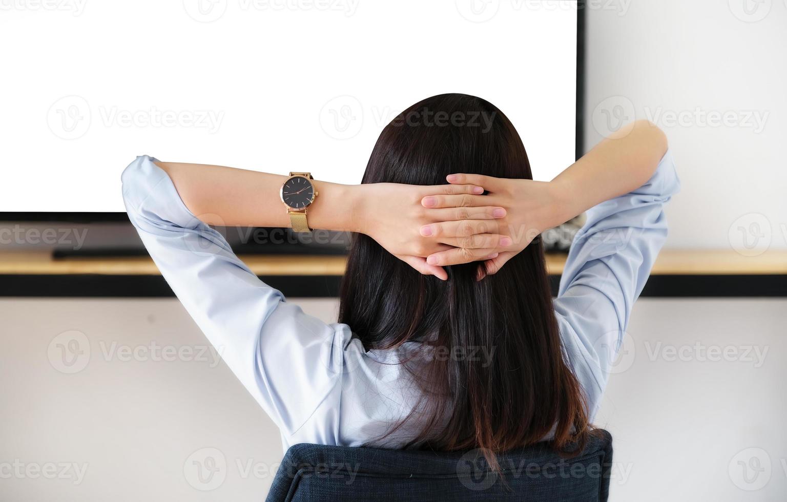 een jonge vrouw die in het weekend uitrust om televisie te kijken, kan de witte ruimte op de tv in tekst of afbeeldingen worden ingevoegd. foto