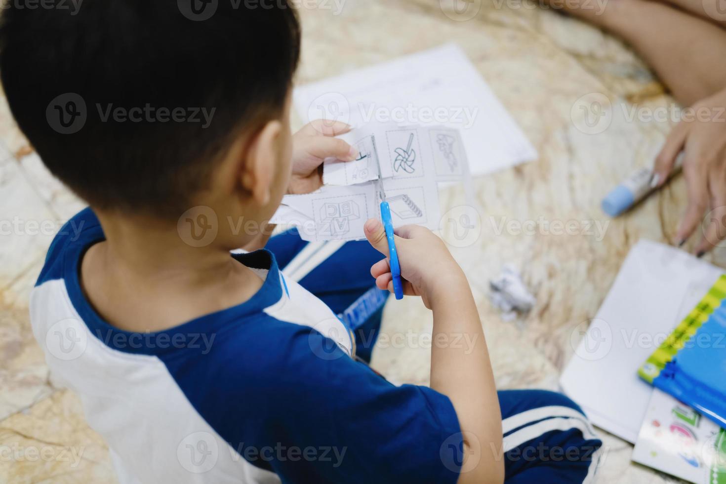 kinderen leren een schaar te gebruiken om papier te knippen. foto