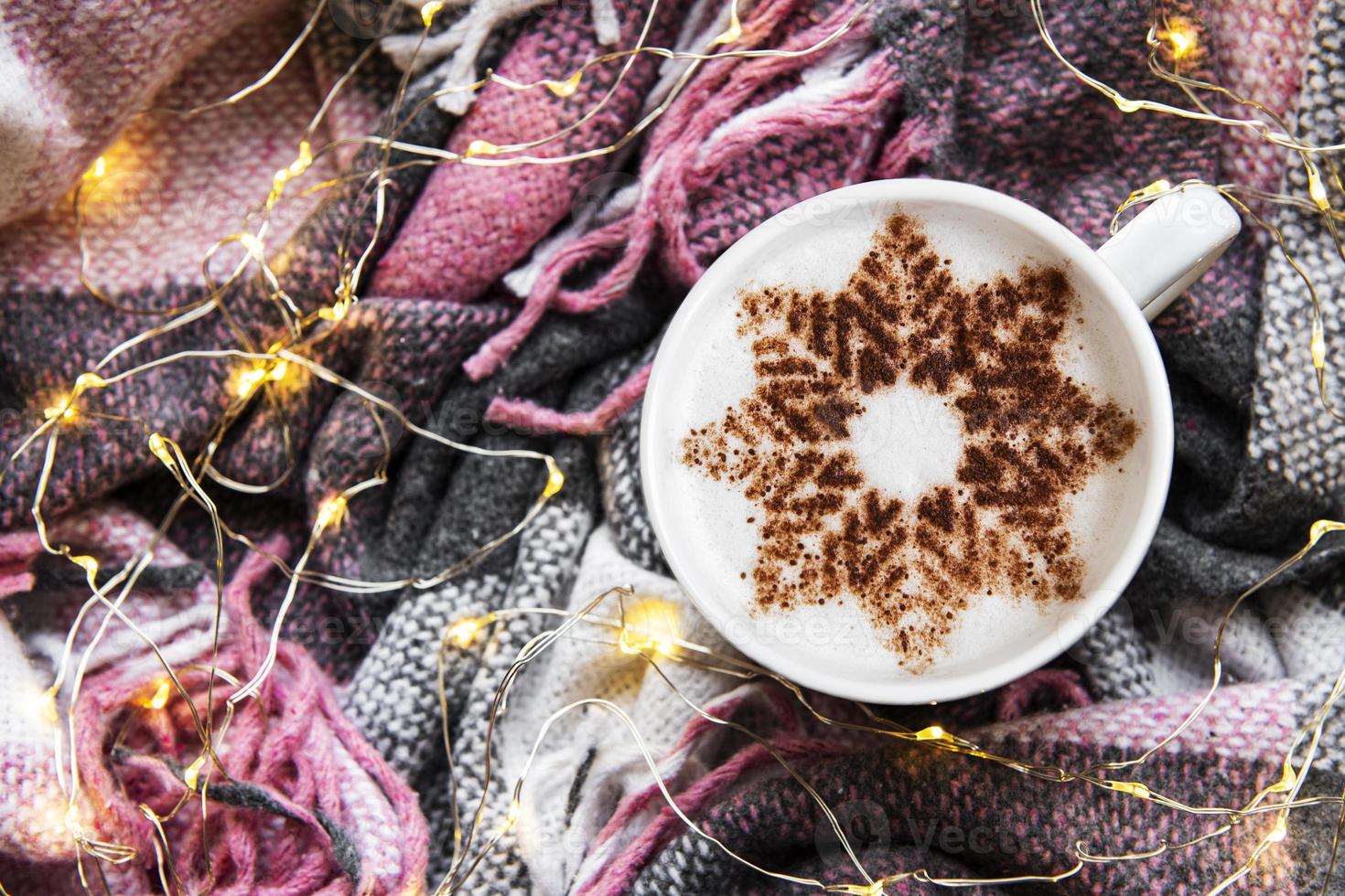 koffie met een sneeuwvlokpatroon op een warme wollen plaid foto