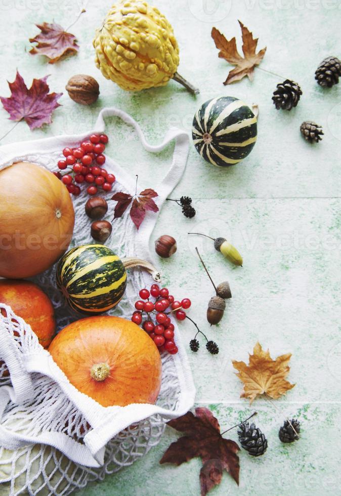 herfstcompositie met diverse pompoenen in eco string bag foto
