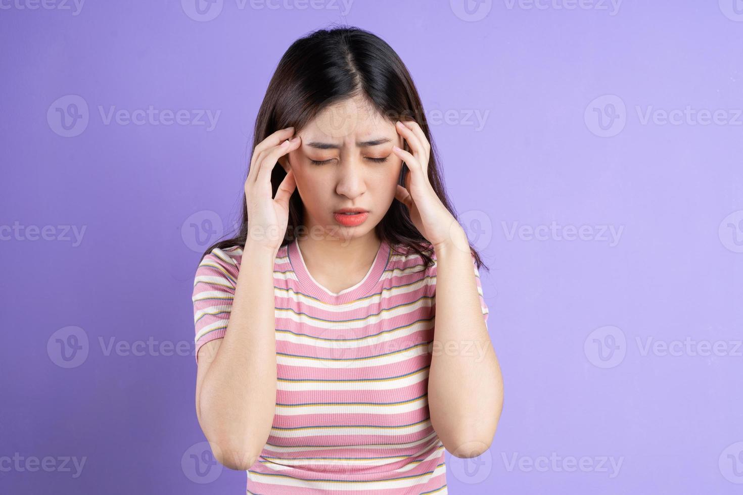 mooie Aziatische vrouw portret, geïsoleerd op paarse achtergrond foto