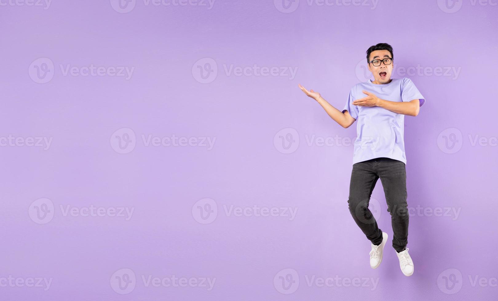 portret van een springende Aziatische man, geïsoleerd op een paarse achtergrond foto