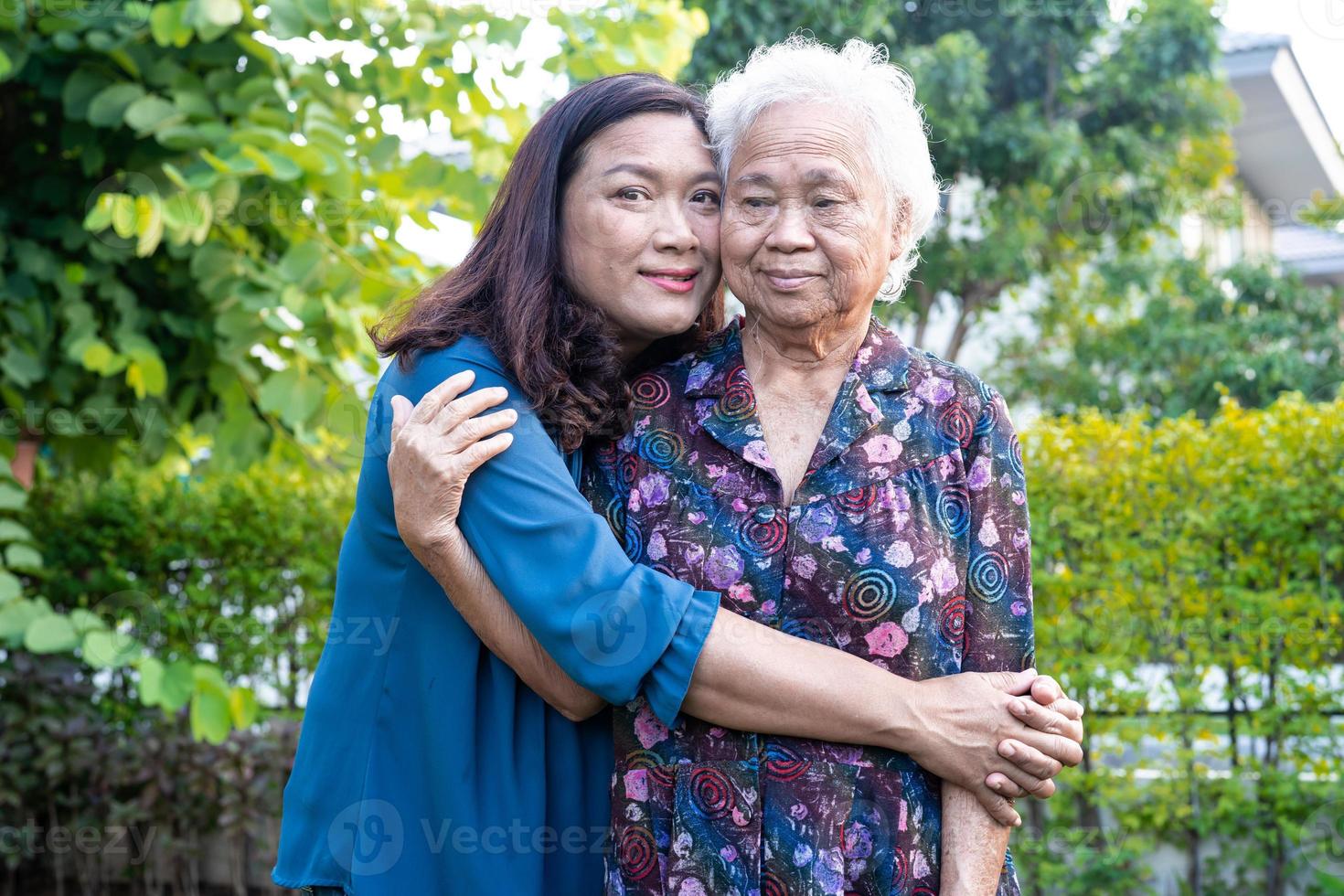 Aziatische oudere vrouw met verzorger wandelen met gelukkig in natuurpark. foto