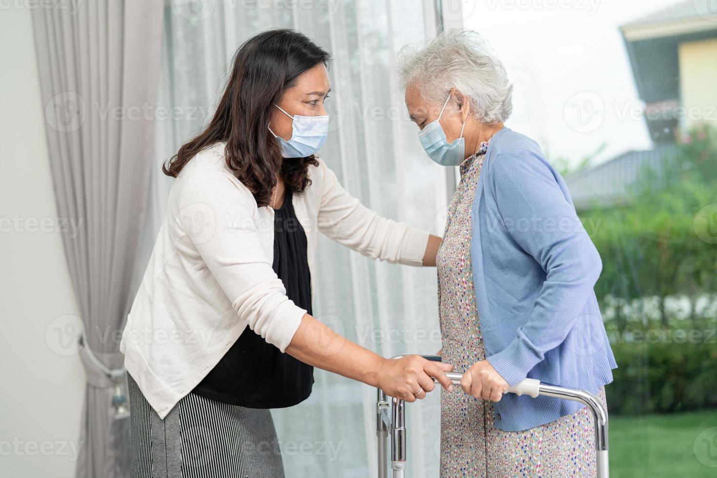 help en zorg aziatische senior of oudere oude dame vrouw gebruik rollator met een sterke gezondheid tijdens het wandelen in het ziekenhuis. foto