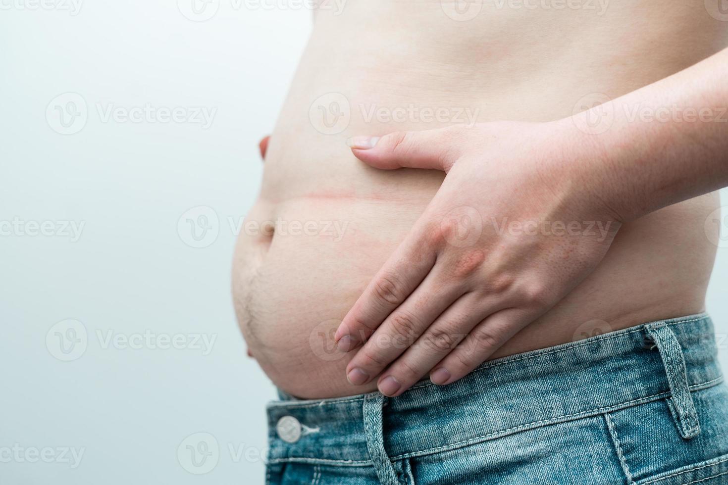afbeelding van de zwaarlijvige buik van de man, geïsoleerd op een witte achtergrond foto