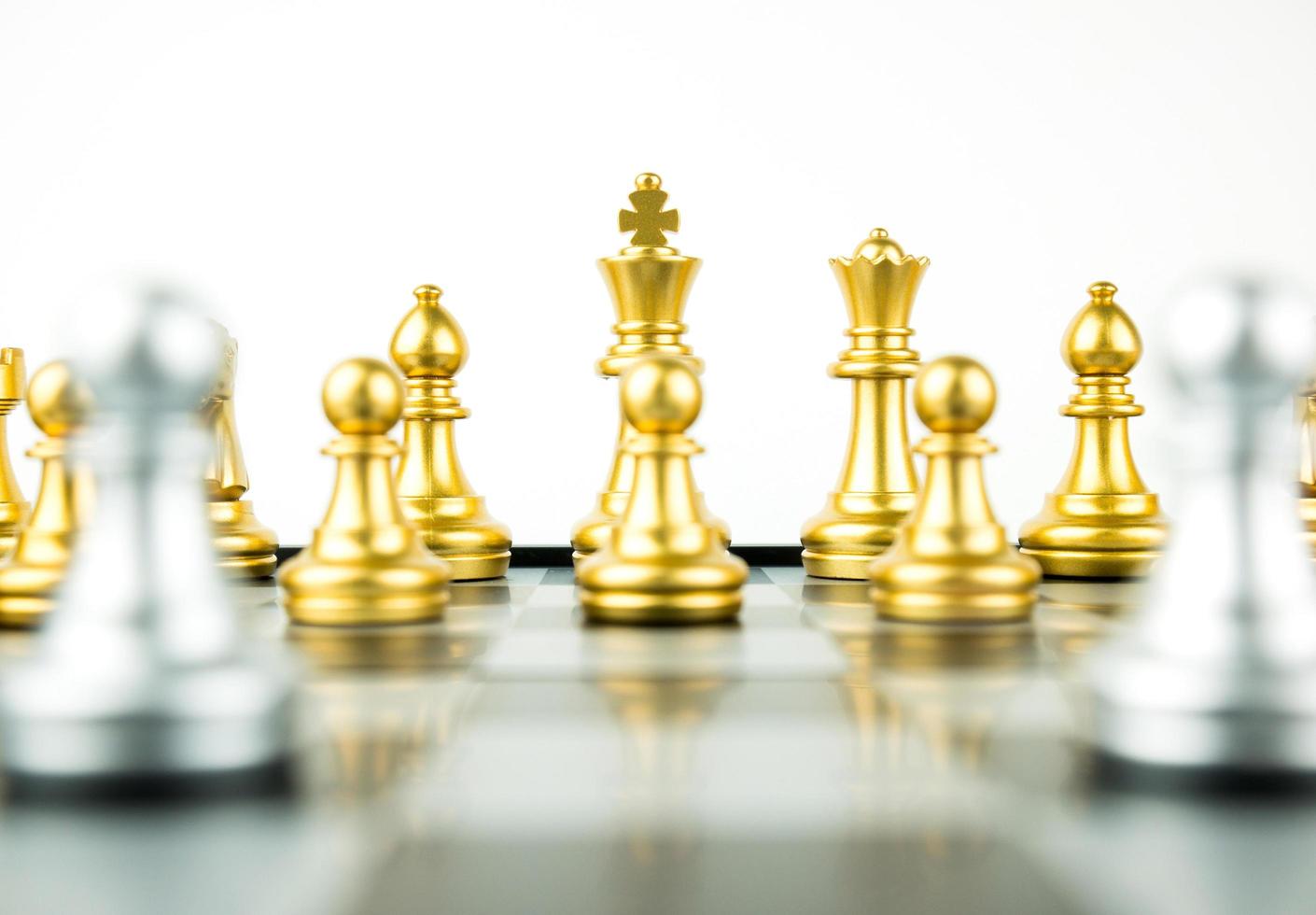 gouden en zilveren koning en ridder van schaakopstelling op witte achtergrond. leider en teamwork concept voor succes. schaakconcept red de koning en red de strategie foto