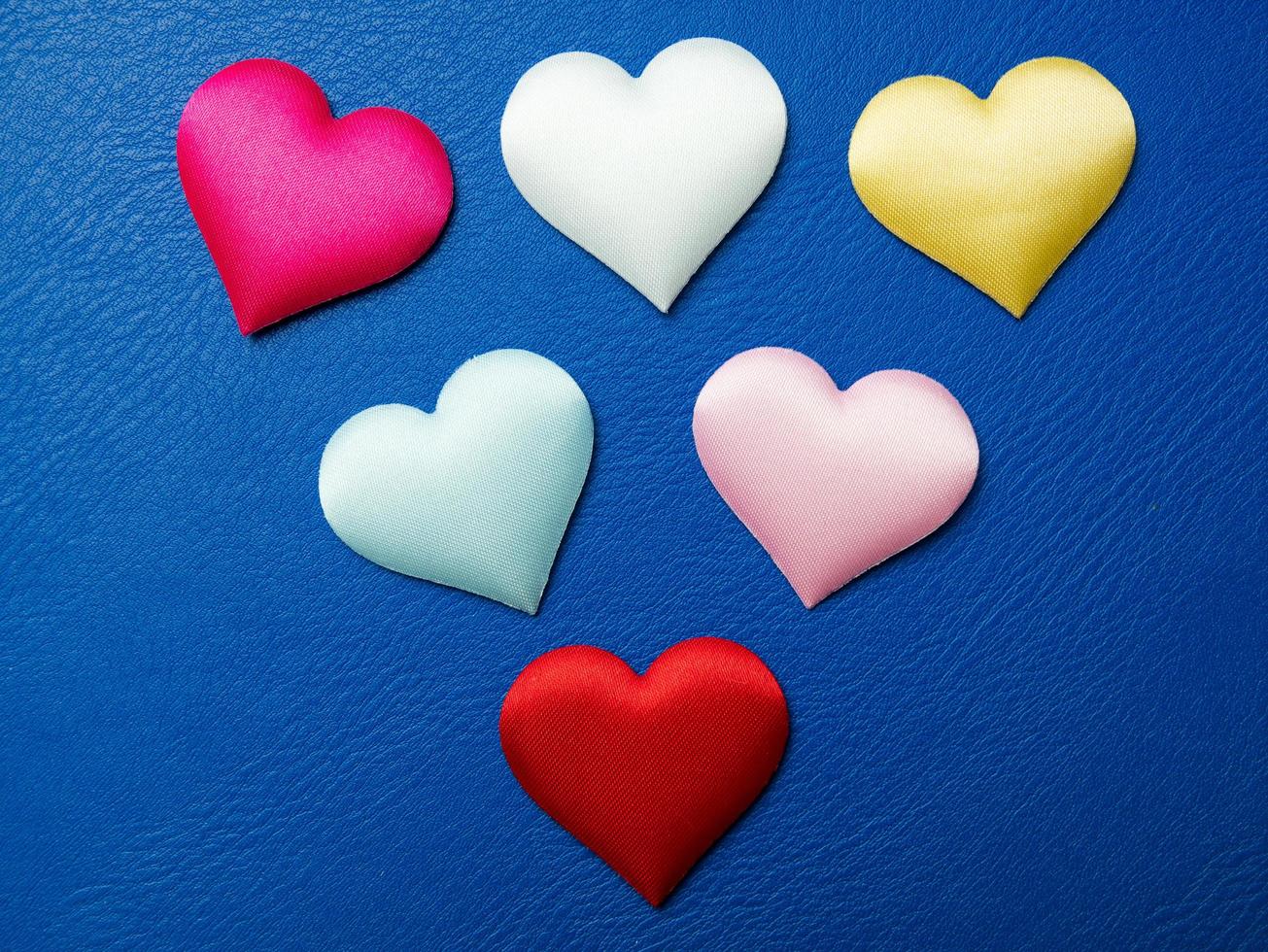 kleurrijke miniharten op blauwe achtergrond, valentijnsversieringen, verschillende harten foto