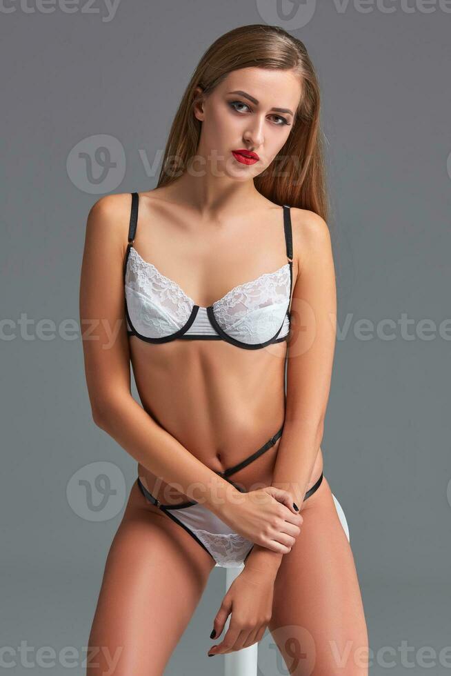 mooi jong vrouw in een sexy lingerie Aan een grijs achtergrond foto