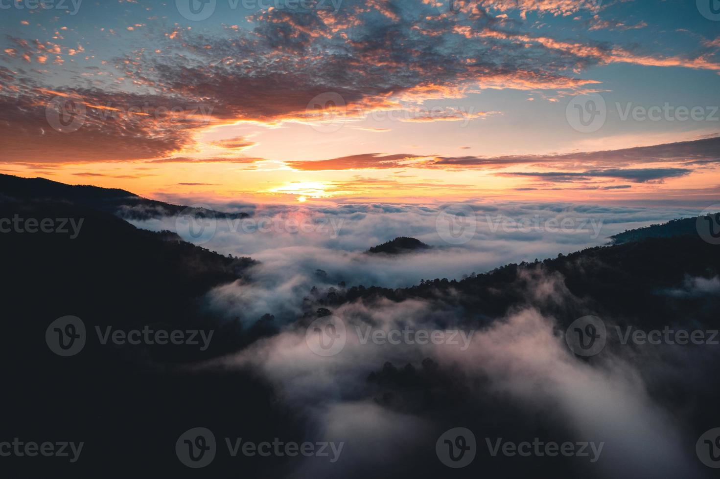 de zon komt op in de mist en de bergen in de ochtend foto