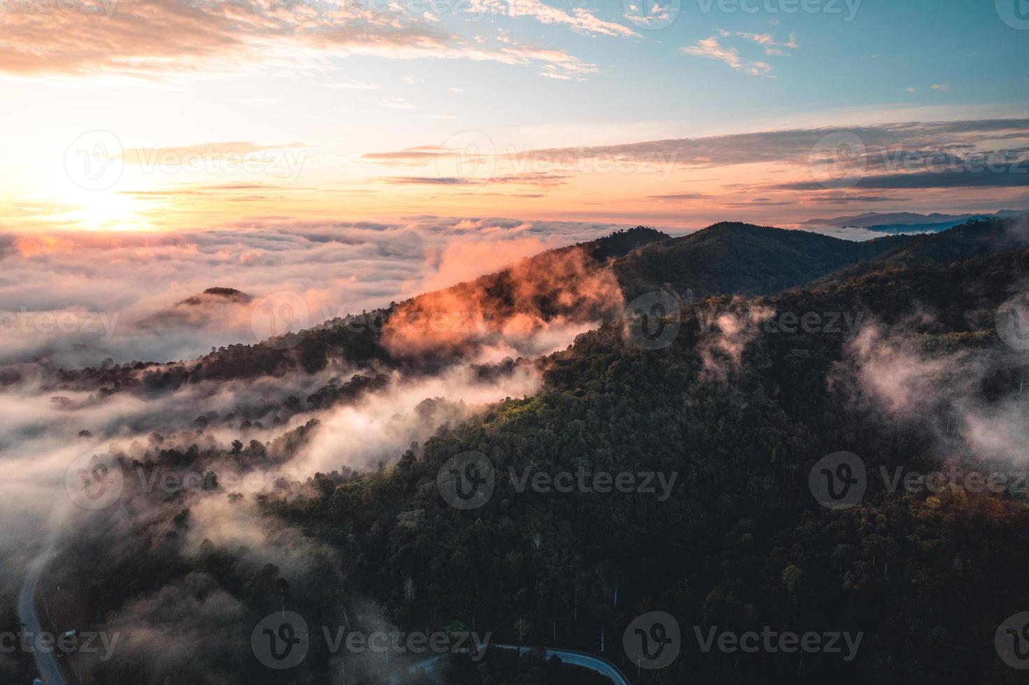 de zon komt op in de mist en de bergen in de ochtend foto