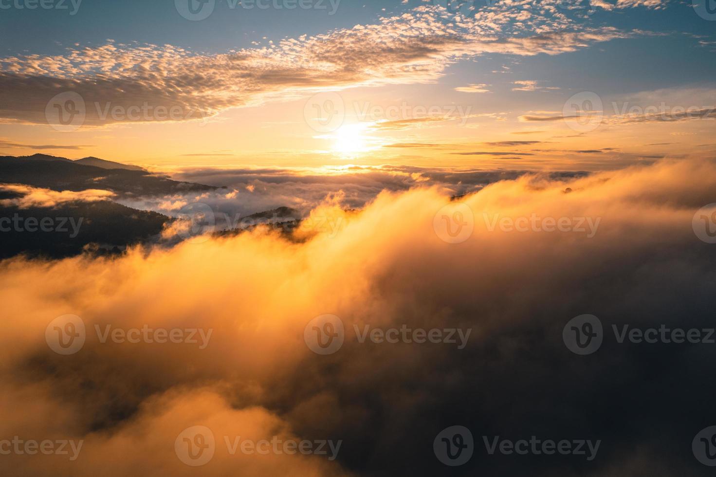 de zon komt op in de mist en de bergen in de ochtend foto