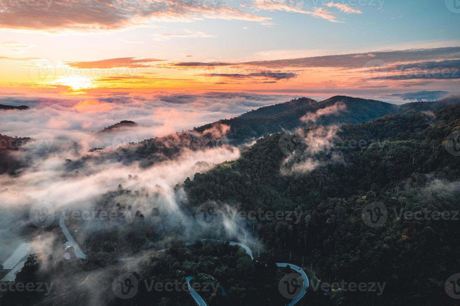 de zon komt op in de mist en de bergen in de ochtend foto