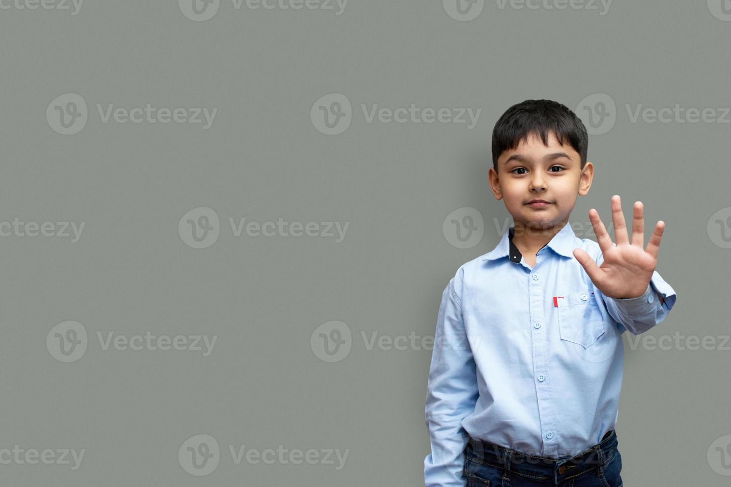 kleine jongen zegt stop met zijn hand geïsoleerd op een effen achtergrond kopie ruimte foto