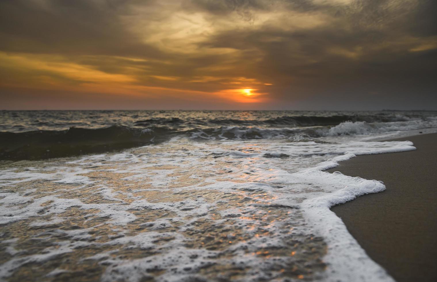 lanscape van zonsondergang hemel strand en zee golf met weinig buitenverlichting. foto