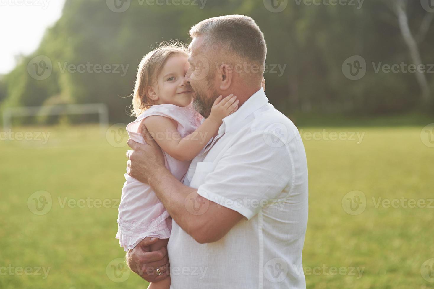 een schattig klein meisje brengt tijd door met haar geliefde grootvader in het park foto