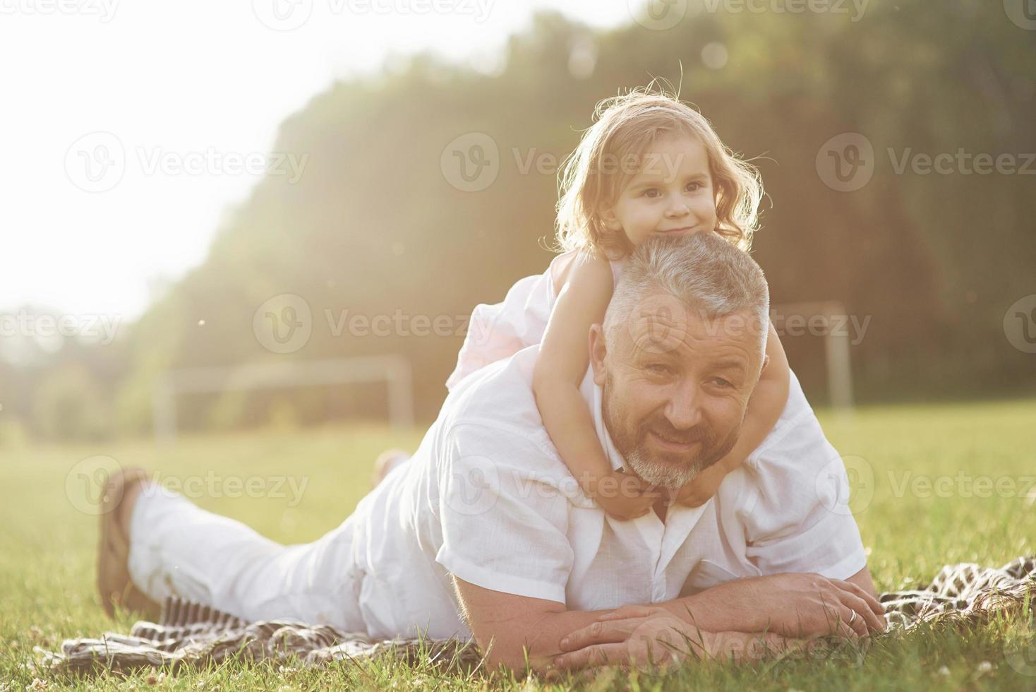 een schattig klein meisje brengt tijd door met haar geliefde grootvader in het park foto