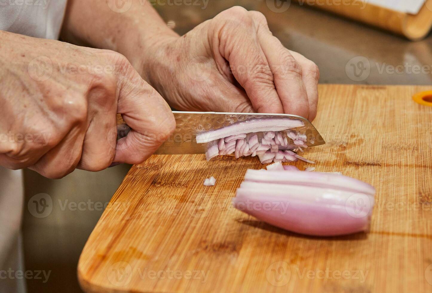 snijden vers sjalotten Aan houten snijdend bord met keuken mes foto