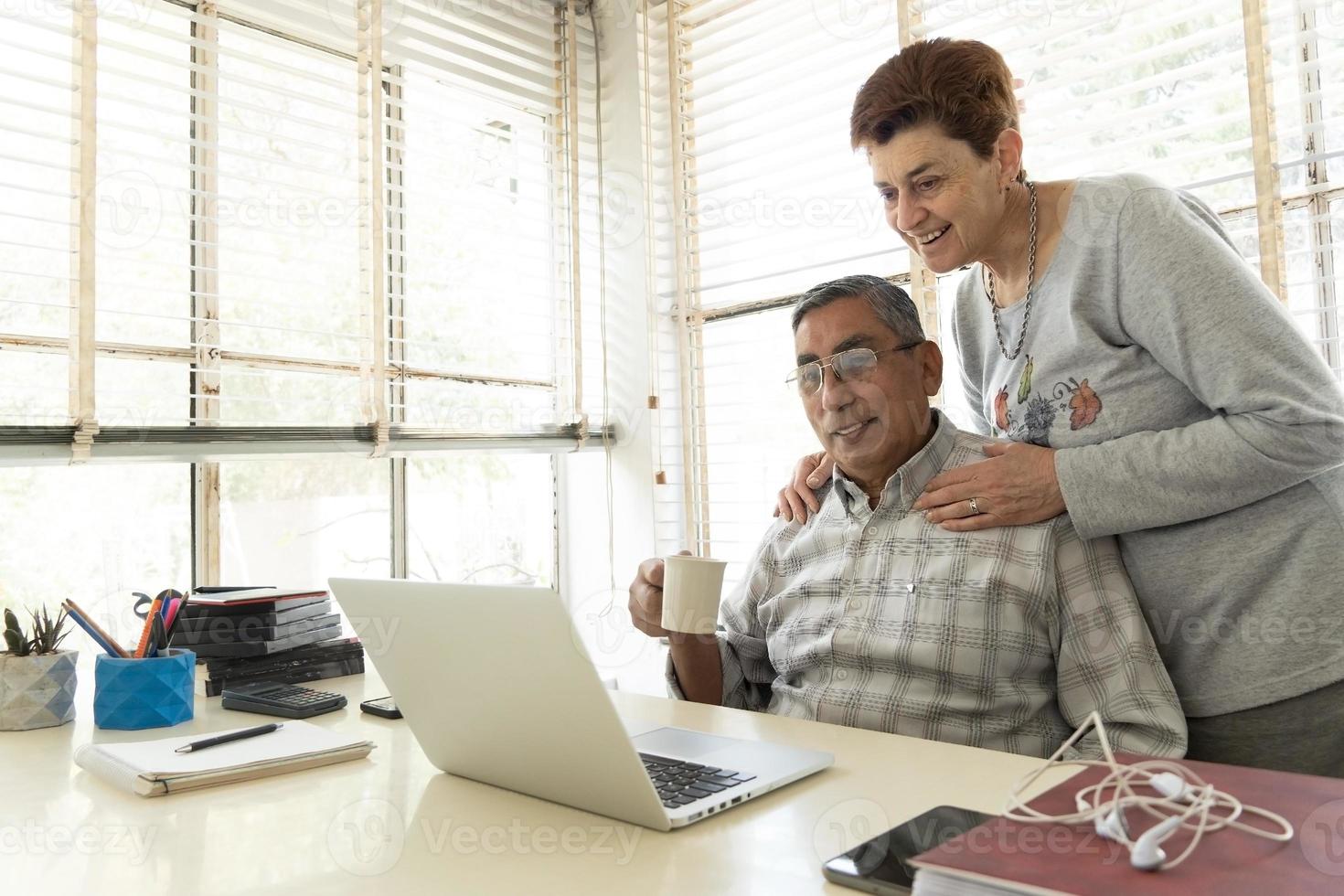 volwassen man en zijn vrouw kijken naar laptop. foto