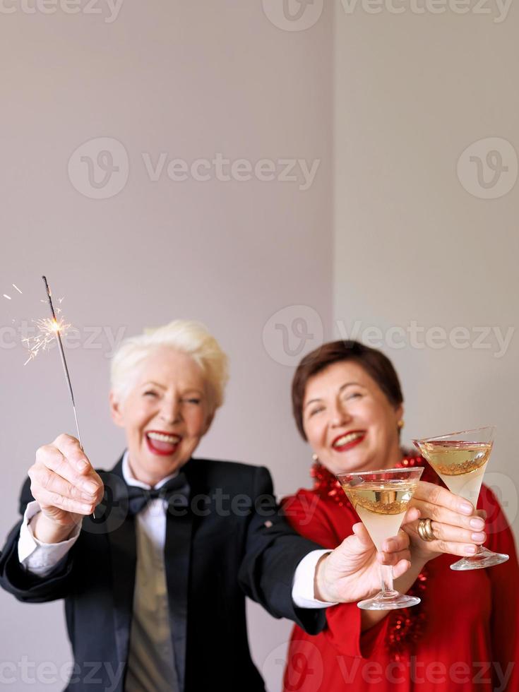 twee mooie stijlvolle volwassen senior vrouwen die nieuwjaar vieren. plezier, feest, stijl, feestconcept foto